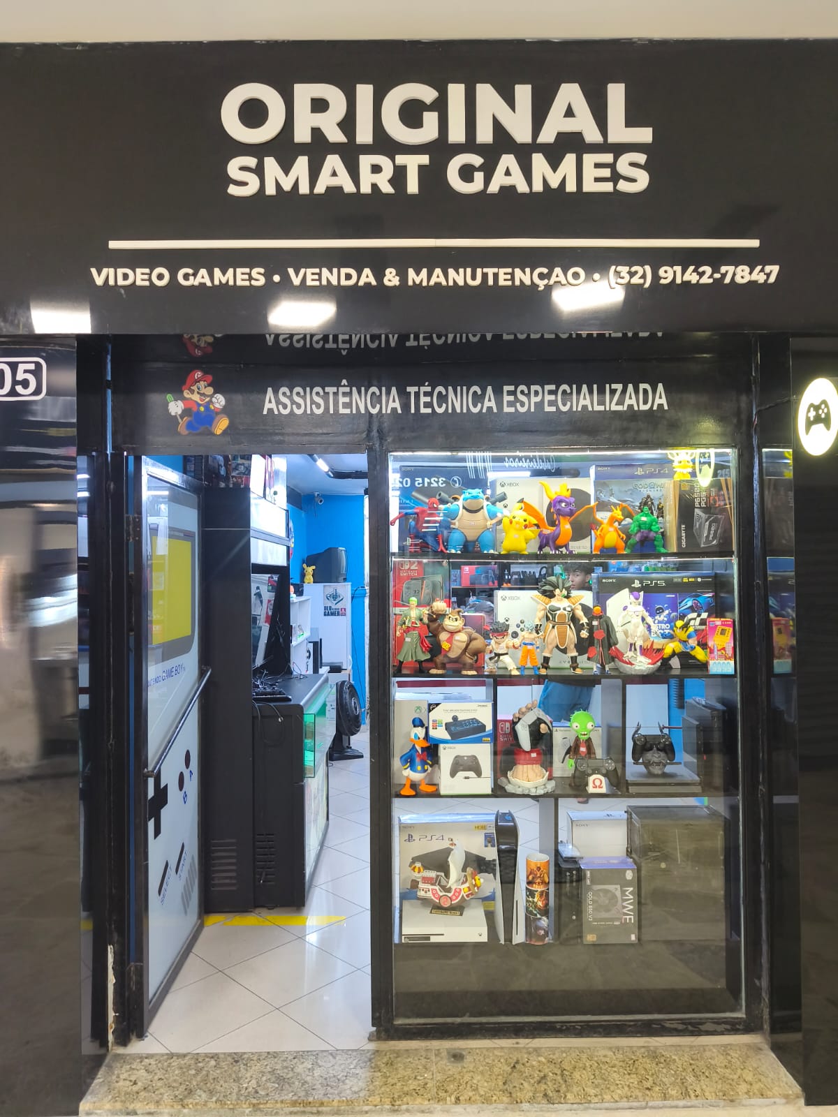 Fachada da loja Original Smart Games com vitrine repleta de consoles, jogos e action figures